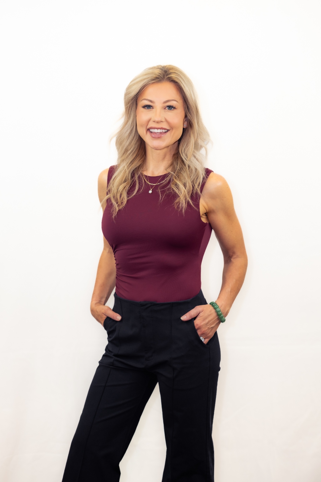 Brenda Powers — elegant portrait in burgundy, white background, confident posture
