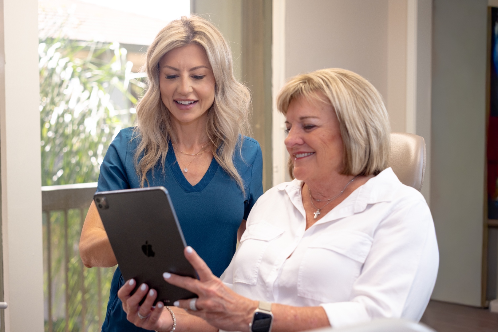 Brenda Powers reviewing health information with a patient on an iPad