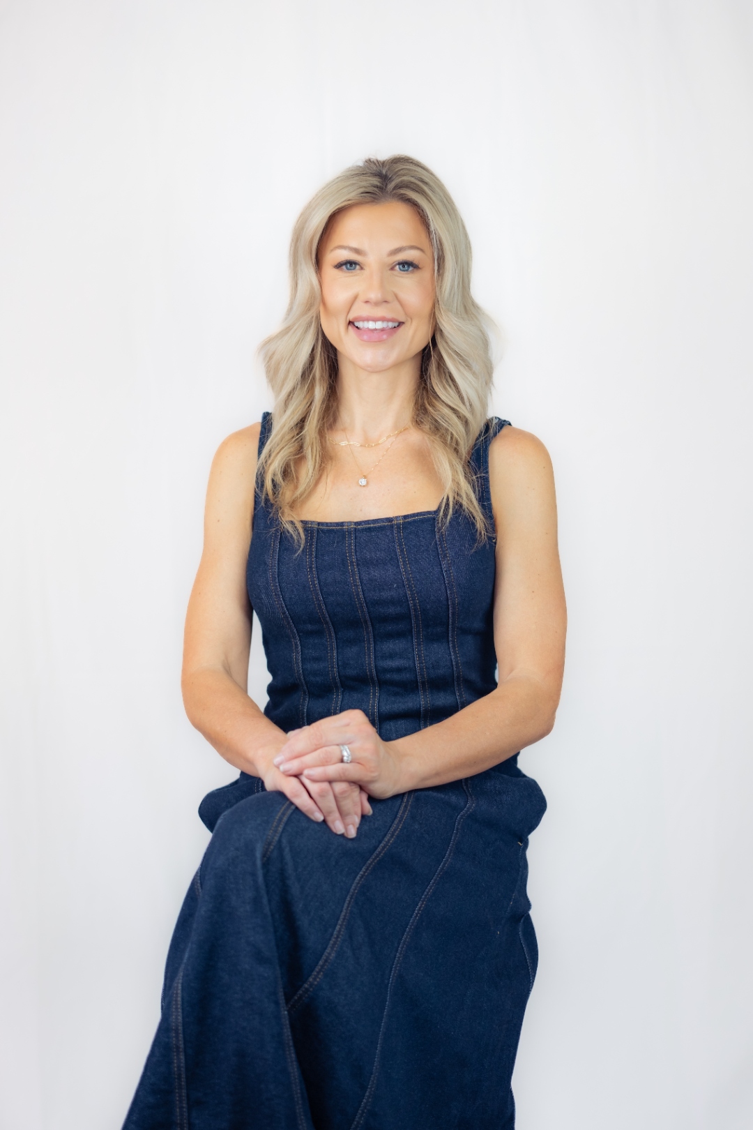 Brenda Powers — professional portrait in denim outfit, warm smile, white background